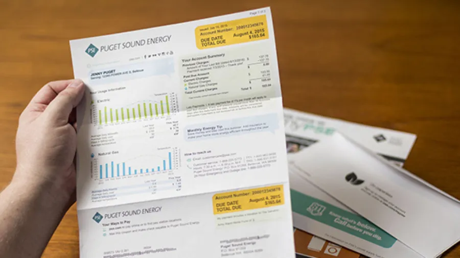 A hand holding a Puget Sound Energy utility bill